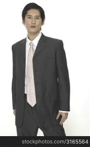 An asian businessman in a smart grey suit with pink tie