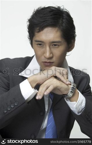 An asian businessman looks serious as he thinks