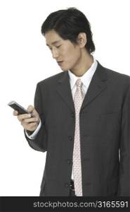 An asian businessman sends a text message on a phone