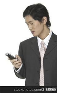 an asian businessman sends a text message on his phone