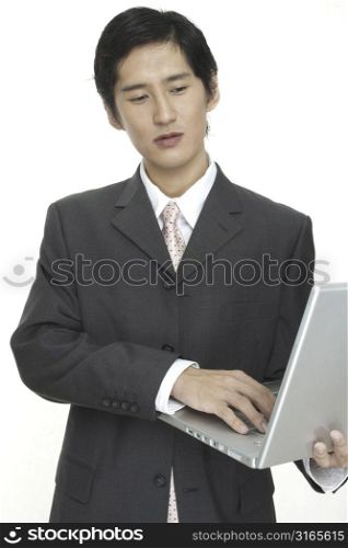 An asian businessman uses a laptop on the move