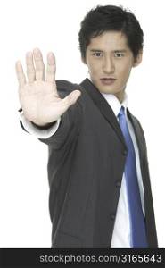 An asian businessman with his hand raised in a stop gesture