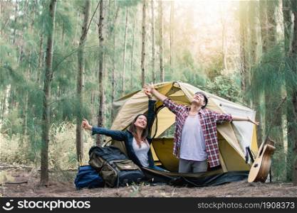 An asian couple waking up in the morning while camping in forest in summer time