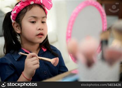 An Asian girl is learning to make up.