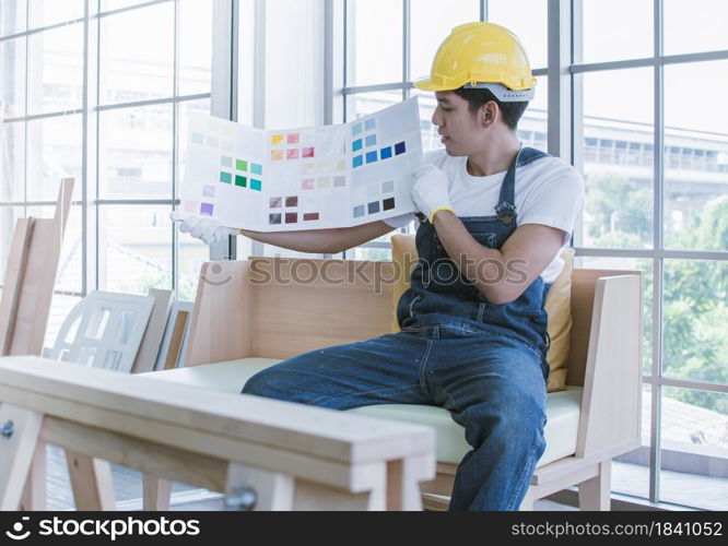 An asian handsome man is choosing colors for house renovation