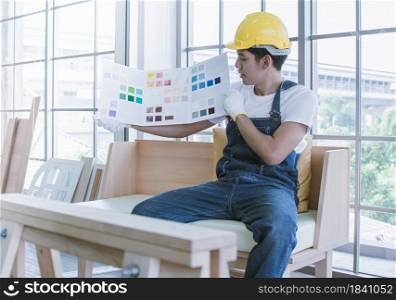 An asian handsome man is choosing colors for house renovation