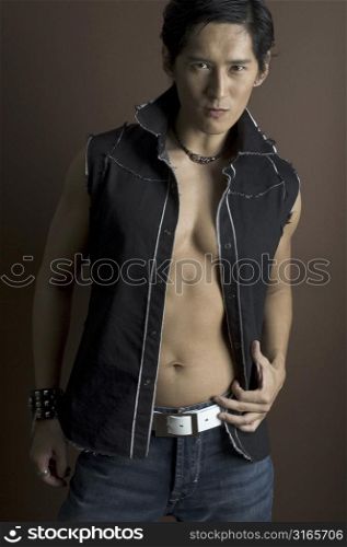 An asian male model in a black top and jeans