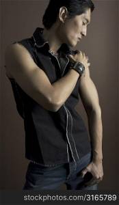 An asian male model in a black waistcoat and accessories