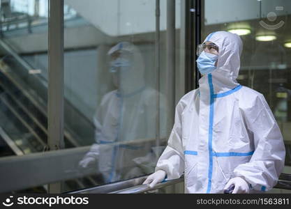 An Asian man is wearing ppe suit in airport elevator , Safety travel , covid-19 protection , social distancing concept .. An Asian man is wearing ppe suit in airport elevator , Safety travel , covid-19 protection , social distancing concept