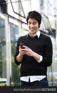 An asian man texting on the cellphone