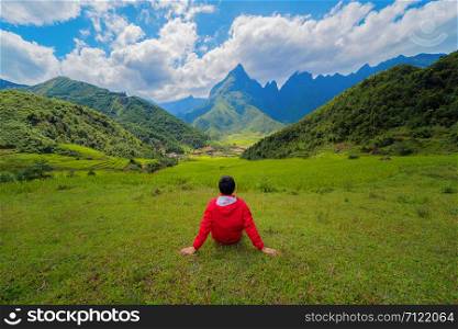 An Asian man watching at Fansipan mountain hills valley on summer in travel trip and holidays vacation concept, Vietnam.