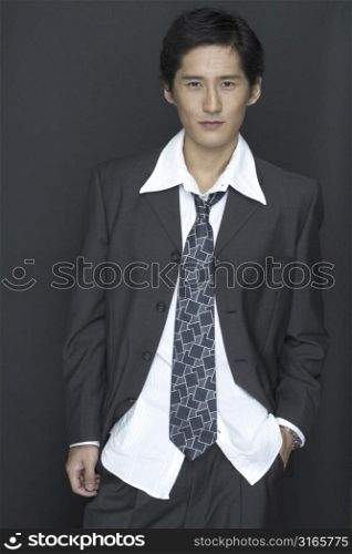 An asian model in a suit with white shirt and patterned tie