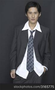 An asian model in a suit with white shirt and patterned tie