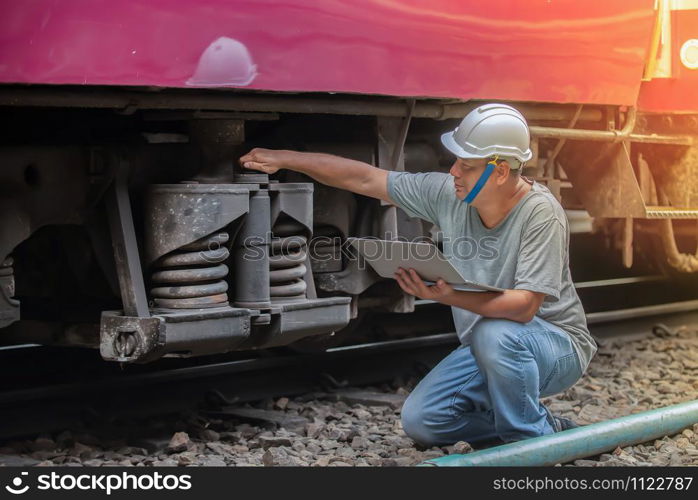 An asian railroad engineer checking a train