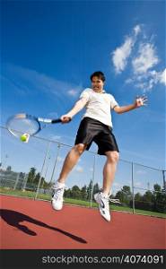 An asian tennis player jumping in the air hitting tennis ball