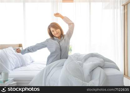 An Asian woman aged about 20 wakes up in the morning in a bright bed in a bedroom or hotel After a restful night&rsquo;s sleep.Asian women with good health Woke up in the morning after sleeping all night