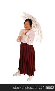 An Asian woman in old fashioned clothing standing for white backgroundand holding an embroidered sun-umbrella wearing a long burgundy skirt.