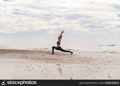 An Asian woman in yoga class club doing exercise and yoga at natural beach and sea coast outdoor in sport and recreation concept. People lifestyle activity.