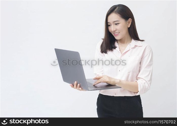 An asian woman is holding laptop computer on white Studio background . . An asian woman is holding laptop computer on white Studio background