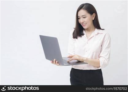 An asian woman is holding laptop computer on white Studio background . . An asian woman is holding laptop computer on white Studio background