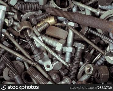 An assortment of bolts, screws, nuts, washers and all kinds of other fasteners piled in a toolbox.