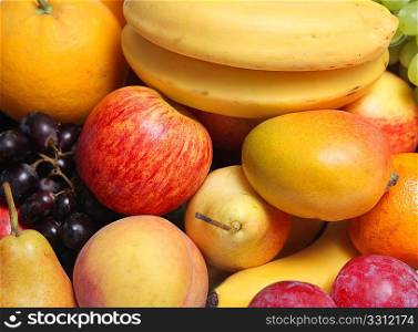 An assortment of fresh fruits, including apple, mango, banana, grapes, pears, oranges and plums