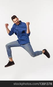 An attractive athletic businessman jumping up against white background.. An attractive athletic businessman jumping up against white background