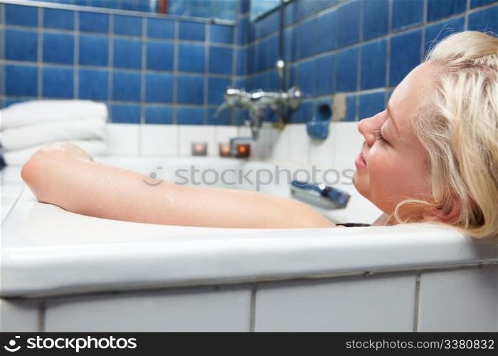 An attractive blonde woman relaxing in spa bath