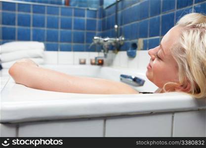 An attractive blonde woman relaxing in spa bath