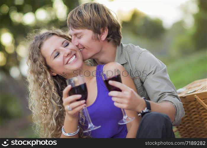 An Attractive Couple Enjoying A Glass Of Wine in the Park Together.