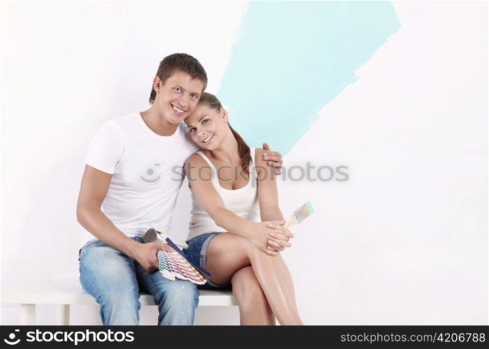 An attractive couple on the background of painted wall