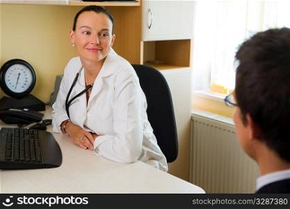An attractive female doctor listening to a male patient, with a blood pressure monitor beside her