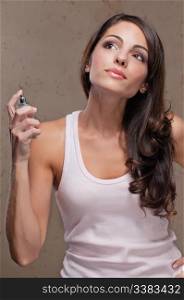An attractive female spraying perfume on herself