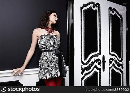An attractive girl in a dress with black and white doors