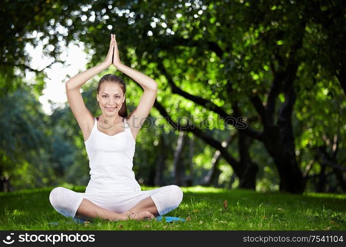 An attractive girl in a pose of yoga outdoors