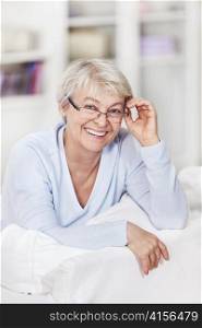 An attractive older woman with glasses at home