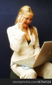 An attractive secretary works on a laptop.