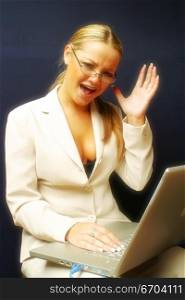 An attractive secretary works on a laptop and is really frustrated.