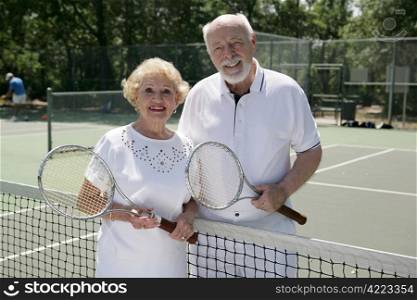 An attractive senior couple ready to play tennis.