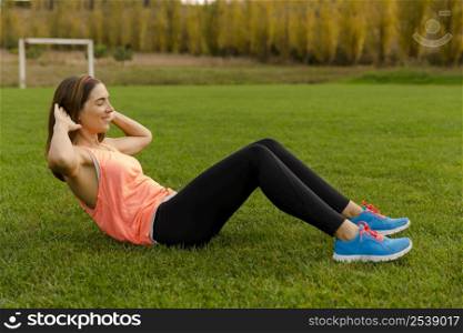 An attractive woman exercising outdoor on a soccer field