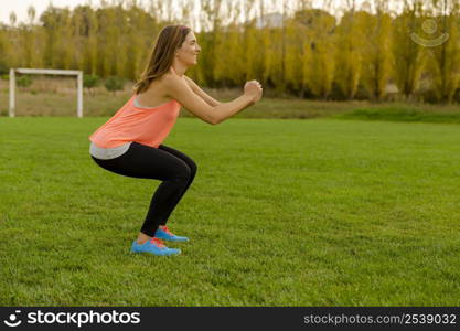 An attractive woman exercising outdoor on a soccer field