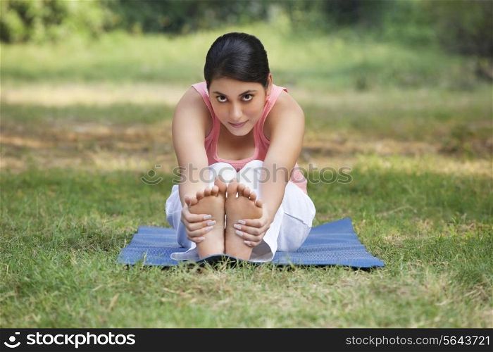 An attractive woman stretching in lawn