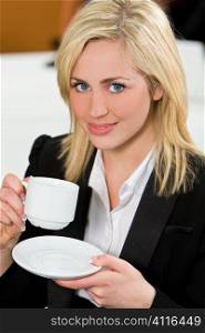 An attractive young female executive takes a coffee break in the office