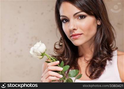 An attractive young female holding a white rose