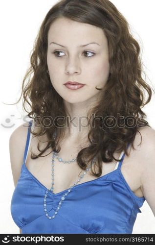 An attractive young female model in a blue top with beads