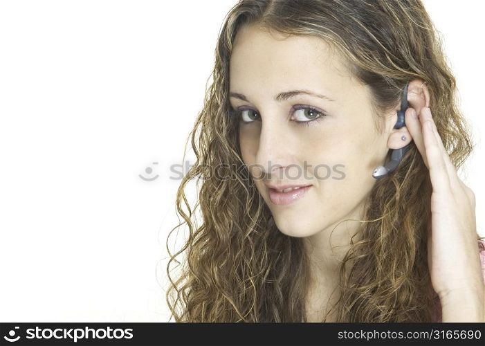 An attractive young model wearing a wireless bluetooth headset