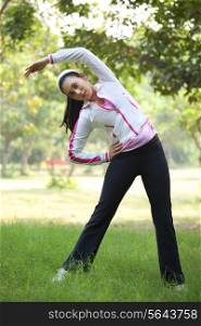 An attractive young woman exercising in park