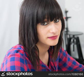 an attractive young woman in a checkered shirt