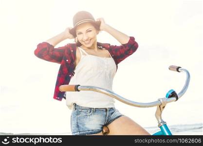 An attractive young woman riding her bicycle on the beach