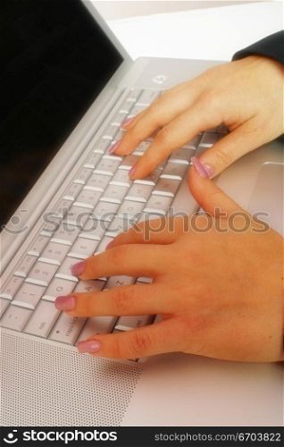 An attractive young woman working on a computer using a mouse.